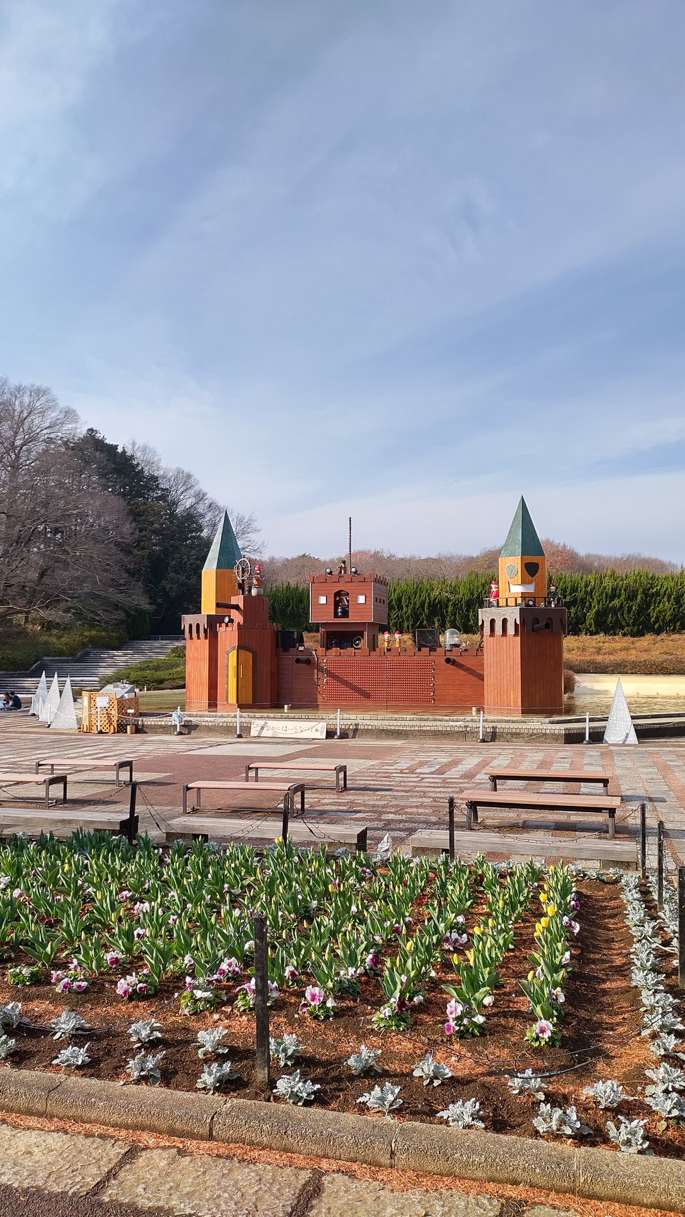 森林公園の花壇と奥に見えるお城のような建物