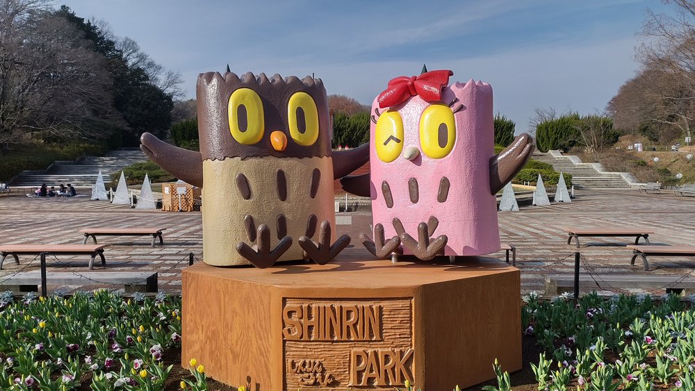 森林公園の広場に立つ2つのフクロウの像